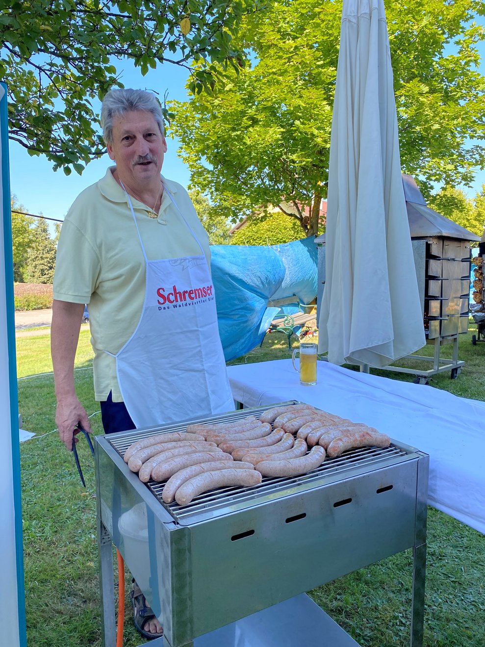 Götzinger Peter hilft beim Würstchen grillen