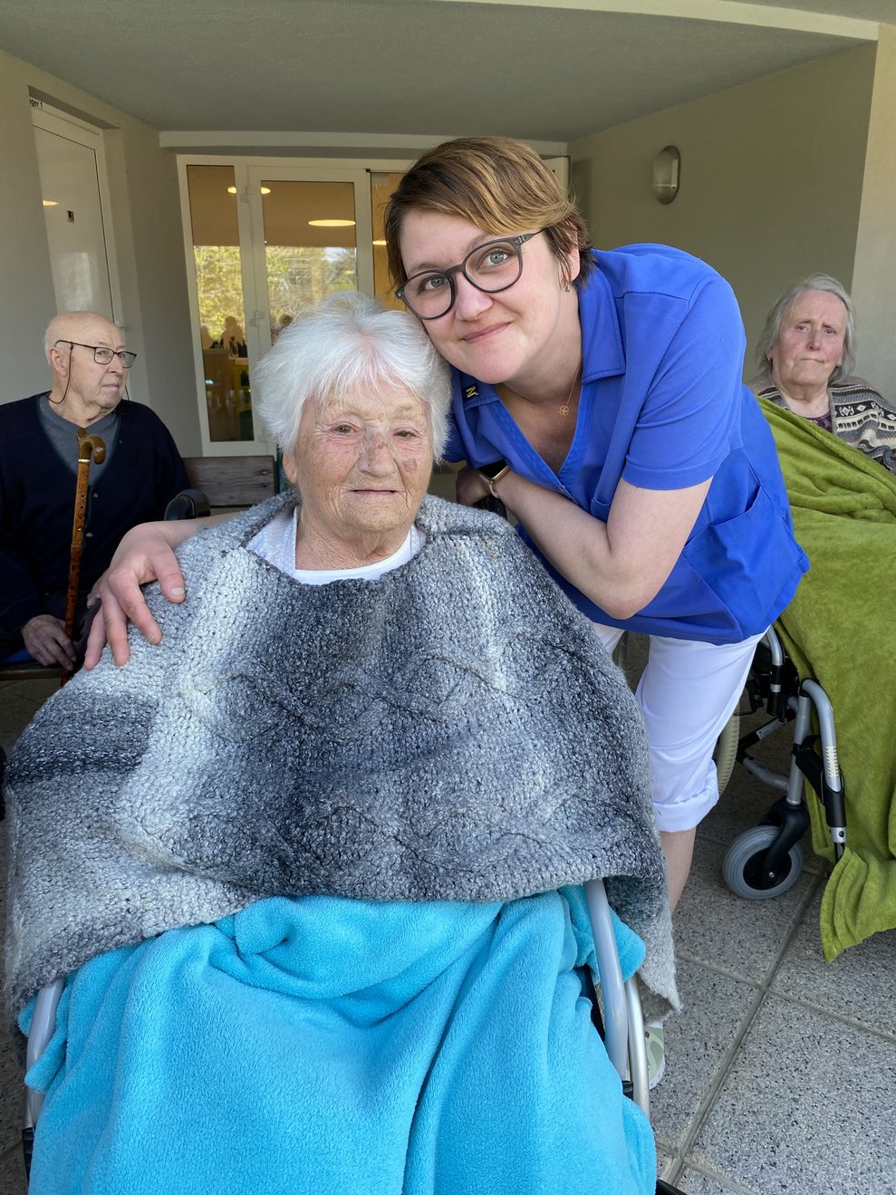 Eveline mit Bewohnerin beobachten das Aufstellen des Maibaumes