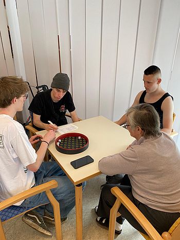 die Burschen spielen "Pokern" mit einer Bewohnerin 