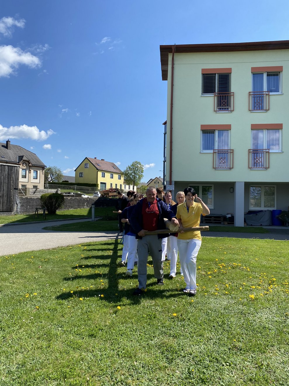 der Maibaum wird zum passenden Ort im Garten gebracht