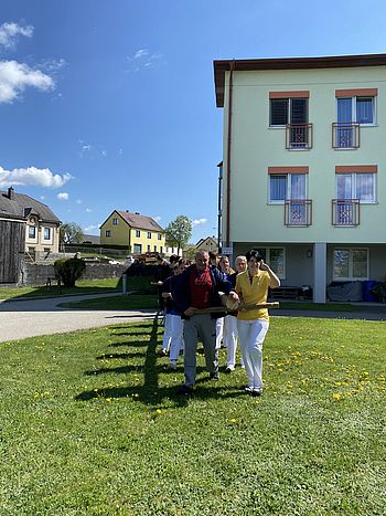 der Maibaum wird zum passenden Ort im Garten gebracht