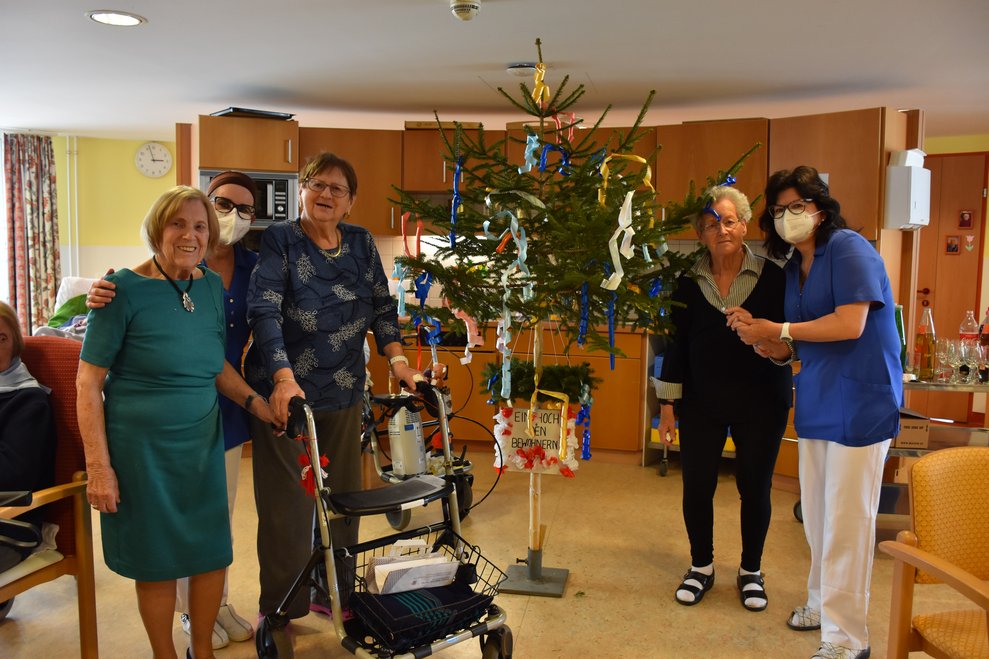 Personen stehen bei Maibaum