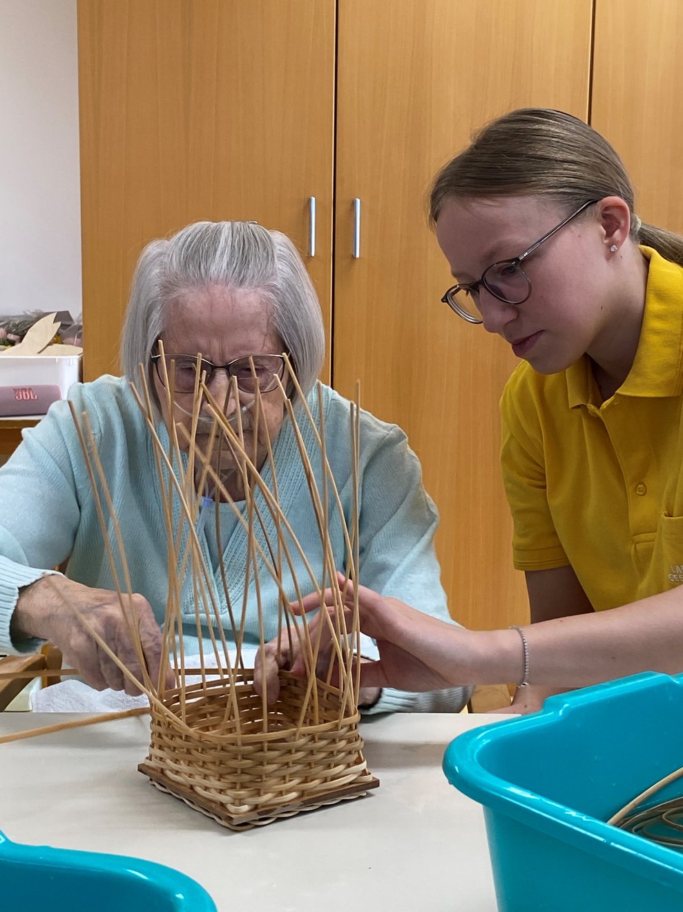 FSJ Lisa unterstützt Bewohnerin beim flechten