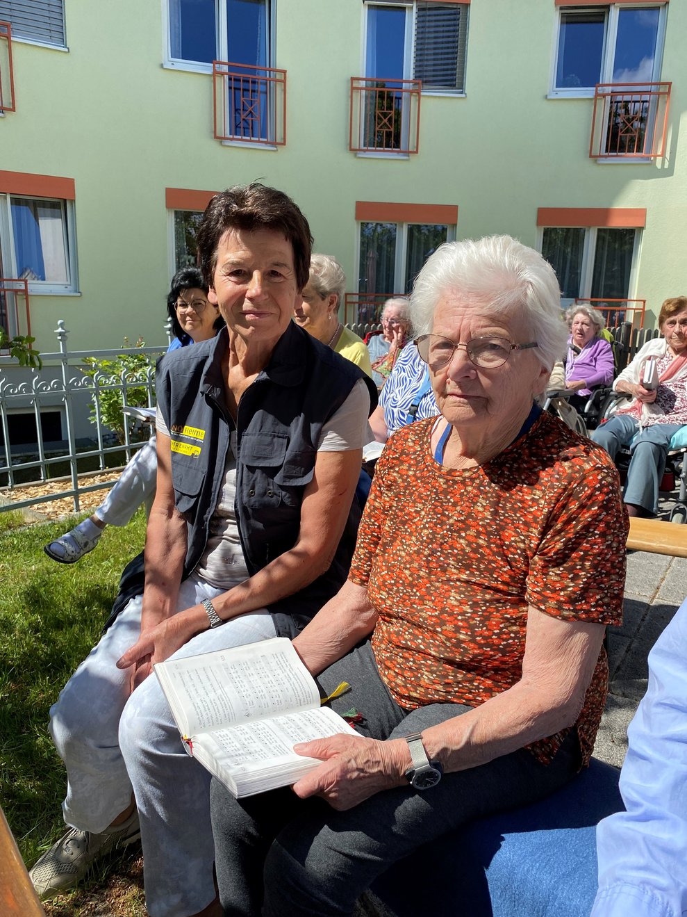 Bewohnerin und Freiwillige Mitarbeiterin bei der Andacht im Rosengarten