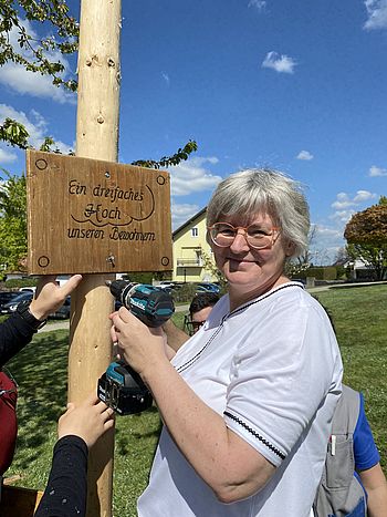Pflegedirektorin Andrea Wingelhofer montiert das Schild "ein dreifaches Hoch unseren Bewohnern"